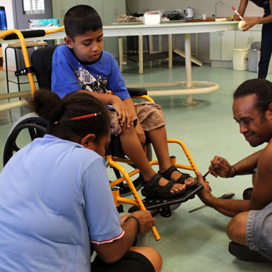A child in Fiji being fitted with his new wheelchair.