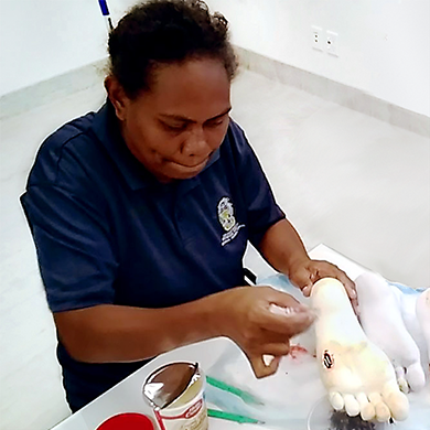 Roselyn practicing foot wound treatment on a plastic foot.