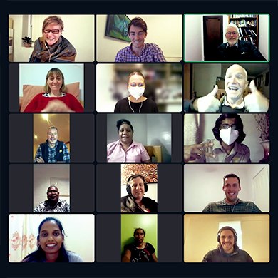 A group of fifteen people on a video call, smiling.